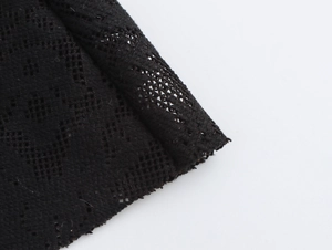 Close-up detail of black lace crochet fabric texture on backless beach maxi dress