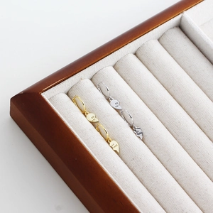 Macro shot of gold and silver heart-shaped Best Friends dangle earrings in a wooden jewelry box