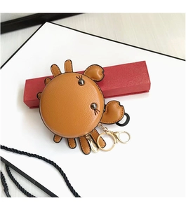 Détail du porte-monnaie en forme de crabe en cuir marron avec porte-clés doré