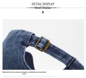 Detailed view of the adjustable bronze metal buckle on dark blue denim baseball cap