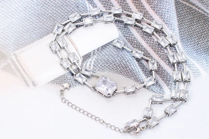Double layered silver necklace featuring baguette cut zircons and star pendant charm