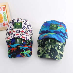 Detail showing kids baseball caps with dinosaur prints and pink woven logo patches