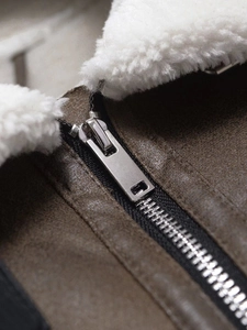 Detail of silver metal zipper and thick faux lamb wool collar on brown suede jacket