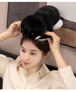 Gros plan d'une peluche pingouin douce tenue au-dessus de la tête montrant taille et texture