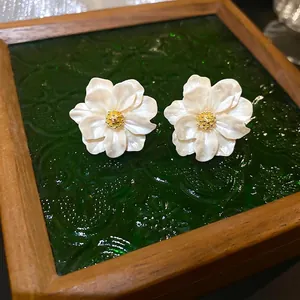 Elegant camellia resin stud earrings with pearl white petals and golden center details