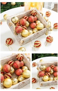 Close-up of red and gold Christmas ball ornaments with glitter and stripes on a tree