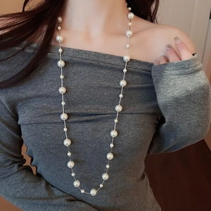 Detail shot of elegant long layered faux pearl necklace with silver chain on model