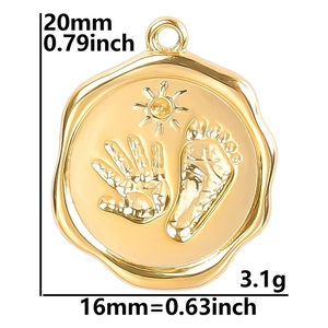 Close-up of gold stainless steel round pendant with embossed hand and foot prints
