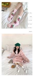 Close-up of soft coral fleece socks with pink strawberry patterns for winter warmth