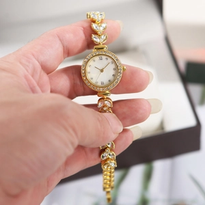 Detail of luxury gold mermaid watch with diamond-set bezel and mother of pearl dial