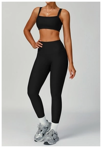 Close-up of black ribbed yoga set featuring a high-waisted leggings and sports bra combo