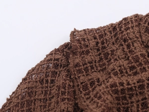 Macro view of brown mesh knit fabric with hollow texture on long sleeve dress
