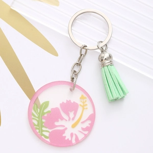 Acrylic keychain with pink flower and green leaf pattern featuring a mint green tassel