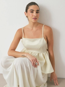 Detail of champagne satin peplum camisole with adjustable straps and glossy finish