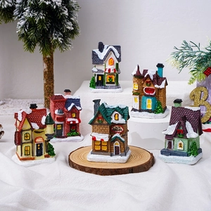 Set of 6 glowing resin Christmas village houses with warm LED lights and artificial snow
