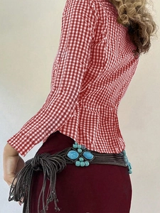 Close-up of deep brown woven cord waist belt with turquoise gemstone and tassel details