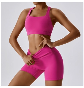 Dettaglio del set yoga rosso rosa con pantaloncini incrociati e reggiseno sportivo