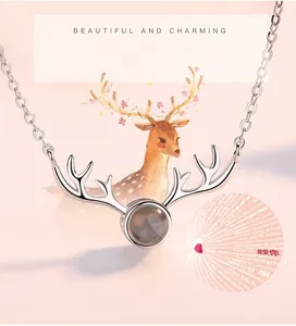 Detailed view of silver reindeer antler necklace with 100 languages I love you stone