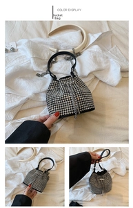 Detailed macro view of the silver rhinestone bucket bag with black handle and chain strap