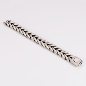 Detail of vintage silver stainless steel woven chain bracelet with secure square clasp