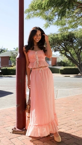 Detailed texture of pink ruffled crop top and drawstring maxi skirt on a model