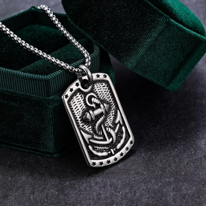 Macro detail of a vintage stainless steel anchor pendant in a green velvet jewelry box