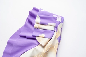 Dettaglio del tessuto da bagno viola con ruches ed eleganti stampe floreali bianche