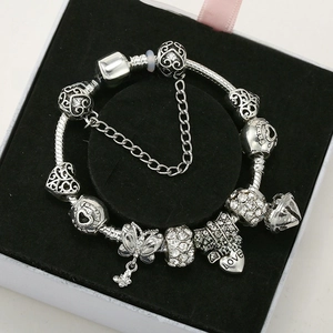 Detail of silver snake chain bracelet with Love heart charms and butterfly pendant