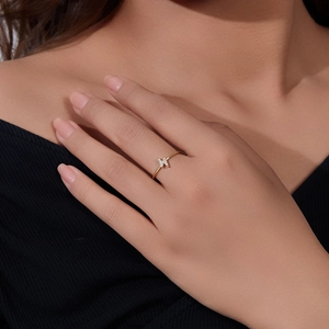 Close-up of golden lightning bolt zircon ring worn on finger, minimalist sterling silver