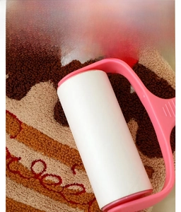 Detail of lint roller cleaning high-density pink coral fleece fabric texture