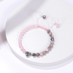 Detailed view of beaded tiger eye bracelet with pink beads and heart projection pendant