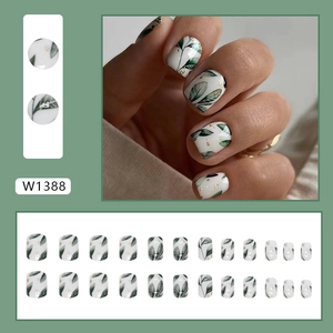 Elegante set kunstnagels met groen bladmotief en gouden folie accenten