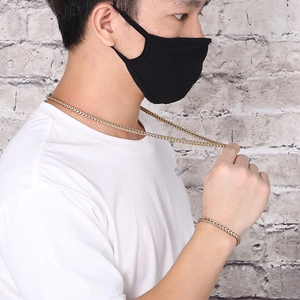 Close-up of a men's gold titanium steel wheat link necklace and matching bracelet set
