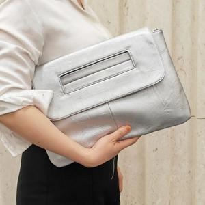 Detail of silver metallic pleated PU leather clutch bag with envelope flap design