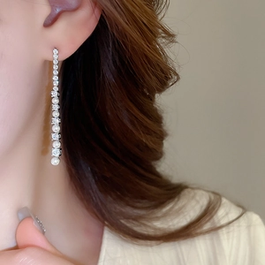Gros plan de boucles d'oreilles pendantes argentées avec perles et zircons sur mannequin