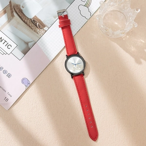Detail of red leather watch strap and silver dial with golden floral motifs