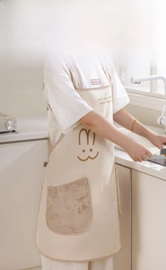 Detail of waterproof beige apron with plush rabbit hand-wiping pocket and H-shape design