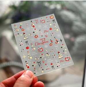 Gros plan des stickers à ongles Noël M-1224 avec motifs de pomme rouge et étoile dorée