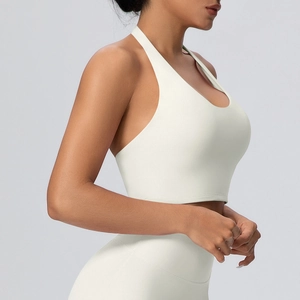 Vista laterale dettagliata del reggiseno yoga allacciato al collo e leggings a vita alta crema