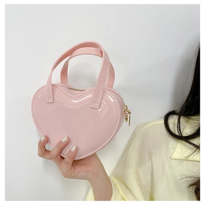 Detail of pink heart-shaped jelly bag with glossy finish and golden metal zipper