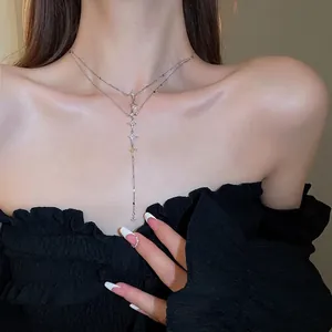 Double-layered stainless steel necklace with sparkling star tassels worn by a model