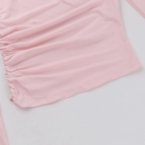 Close-up detail of soft pink ruched fabric with elastic texture and neat hem stitching
