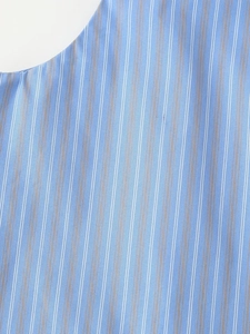 Close-up of blue cotton fabric showing detailed white and beige vertical striped pattern