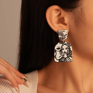 Detailed view of acrylic earrings featuring black and white artistic portrait illustrations