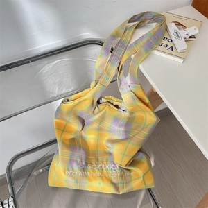 Detail of embroidered logo on large yellow and purple checkered canvas tote bag