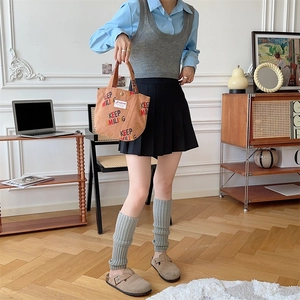 Orange corduroy tote bag with Keep Smiling print styled in a preppy casual outfit