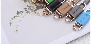 Close-up of assorted PU leather belts in multiple colors with elegant gold metal buckles