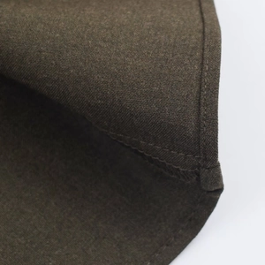 Detail of shoulder pad and textured dark olive fabric with precise stitching quality