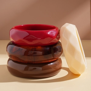 Macro shot of geometric acrylic bangles showing glossy faceted resin surface and rich colors