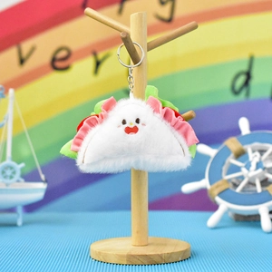 Adorable plush croissant sandwich keychain with an embroidered cute face on a stand